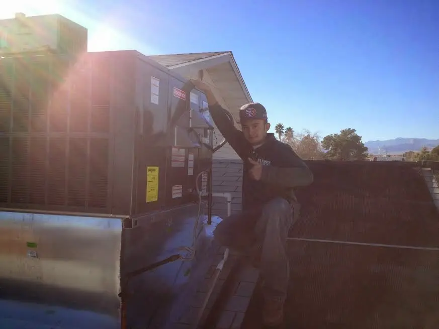 HVAC technician performing Boiler Repair on a rooftop unit in Blair